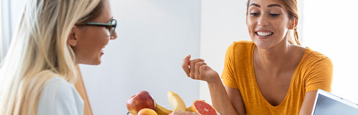 Pharmacist consulting patient beside a bowl of fruits.